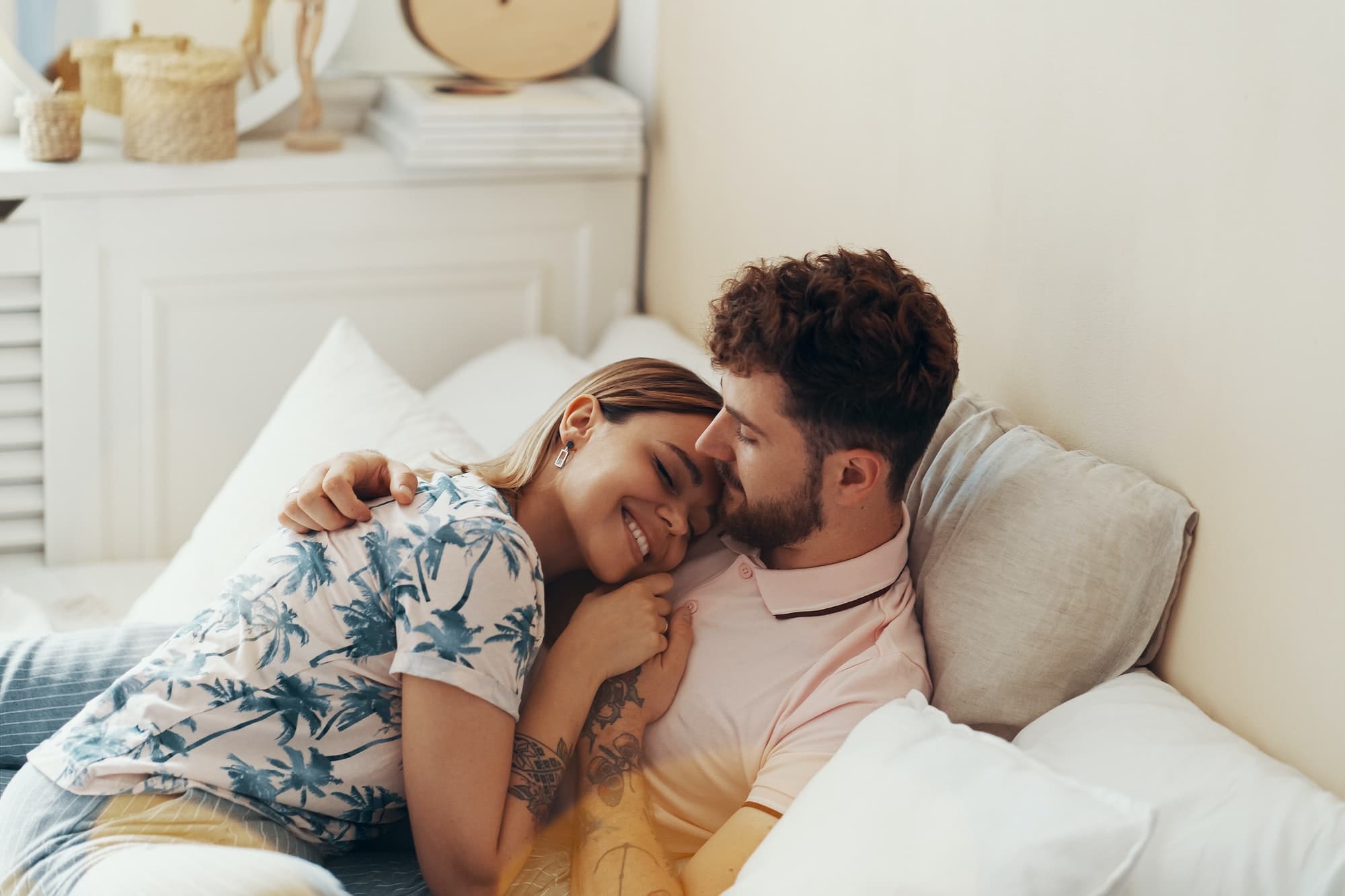 Couple in love is embracing on the bed